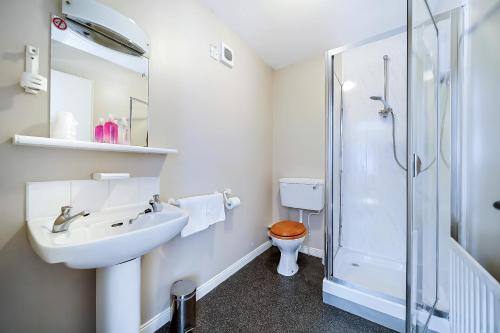 y baño con aseo, lavabo y ducha. en Iona Inn, en Derry Londonderry
