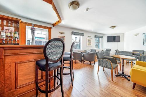 a bar with chairs and tables in a restaurant at Iona Inn in Derry Londonderry