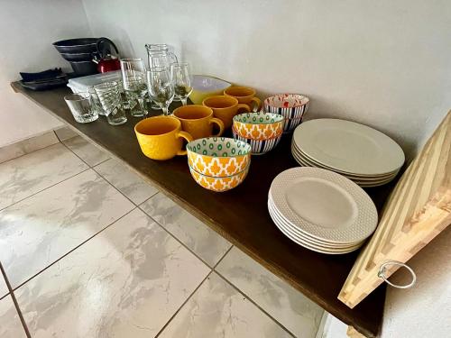 a table with plates and bowls and glasses on it at Casa Paraiso Tropical in Parrita
