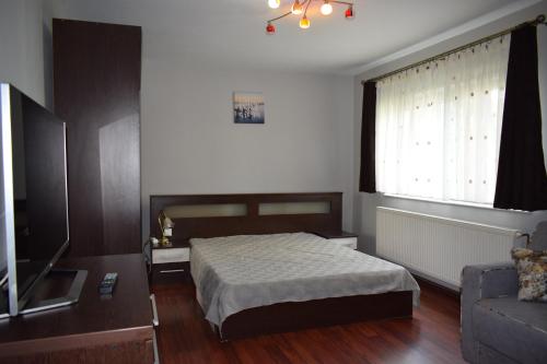 a bedroom with a bed and a couch and a window at Apartament Cathedral View Republicii RHBM in Baia Mare