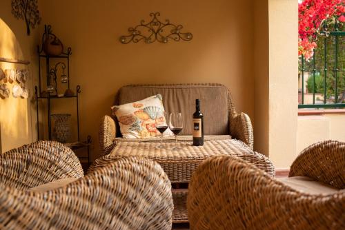 una mesa con una botella de vino y dos sillas en Delizioso appartamento nel Golfo di Orosei con veranda, en Cala Liberotto