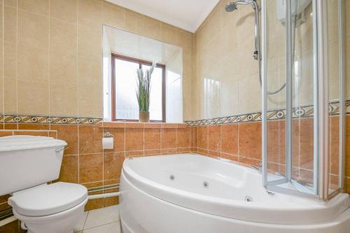 a bathroom with a tub and a toilet and a sink at Faulds Crescent Lodge ✪ Grampian Lettings Ltd in Aberdeen