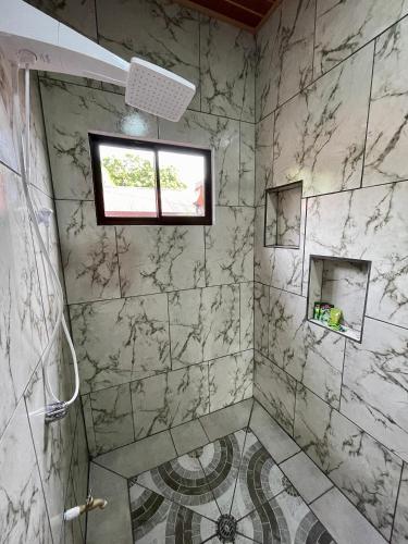 a bathroom with a marble shower with a window at Casa Paraiso Tropical in Parrita