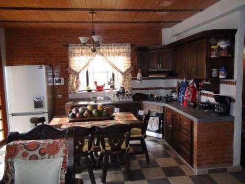 een keuken met een tafel met stoelen en een koelkast bij Casa Matisa in Rivera