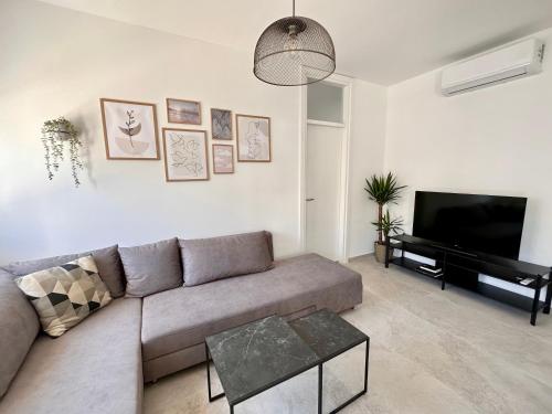 Una sala de estar con un sofá y un televisor de pantalla plana. en Clouds Apartments Čiovo - 20 meters from Copacabana beach, en Trogir