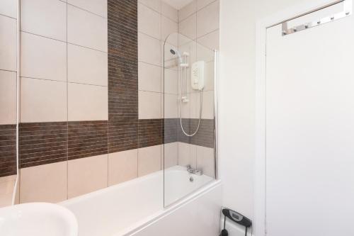 La salle de bains est pourvue d'une douche, d'une baignoire et d'un lavabo. dans l'établissement The Tron Square Residence, à Édimbourg