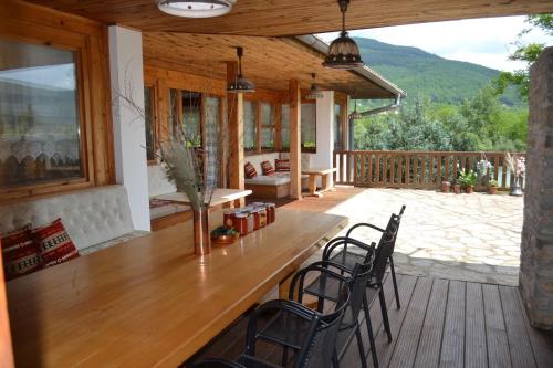 a patio with a wooden table and chairs on a deck at Heritage Home Ustikolina in Foča