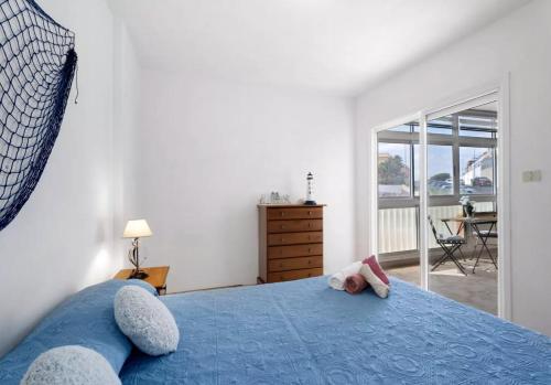 ein Schlafzimmer mit einem blauen Bett mit zwei ausgestopften Tieren in der Unterkunft Arenitas Sunset Apartment 1 in Santa Cruz de Tenerife