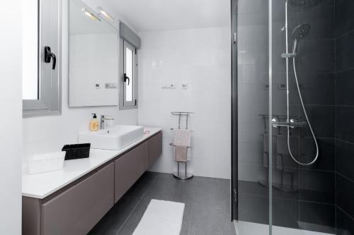 een witte badkamer met een douche en een wastafel bij Villa near the sea in Pilar de la Horadada