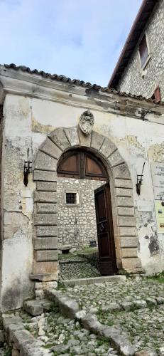un ancien bâtiment en pierre avec une porte voûtée dans l'établissement Castello di Fumone, à Fumone