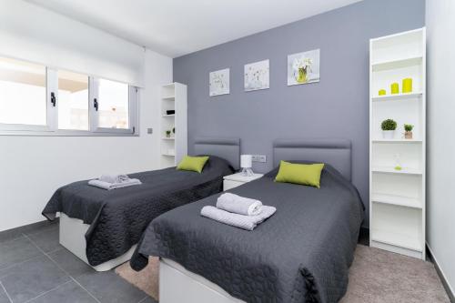 twee bedden in een slaapkamer met blauwe muren bij Villa near the sea in Pilar de la Horadada