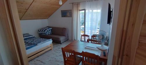 a living room with a bed and a dining room table at Villa Rosa pokoje u Marzeny in Władysławowo