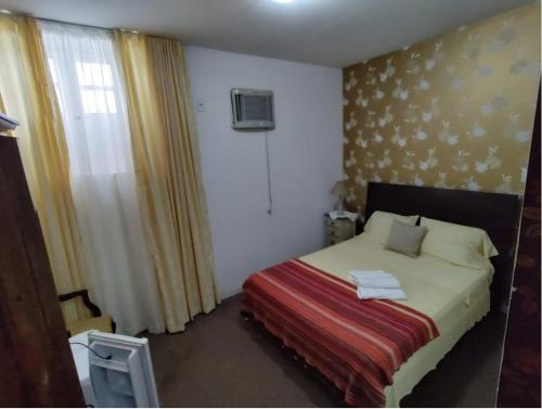 um quarto com uma cama com um cobertor vermelho em Pousada Barroco na Bahia em Salvador