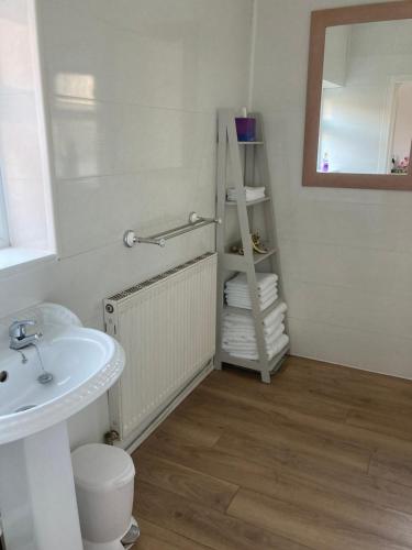 a bathroom with a sink and a mirror and towels at Seaferns in Weston-super-Mare