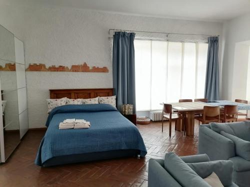 1 dormitorio con 1 cama azul y comedor en Delizioso Open Space da Letizia, en Pomezia