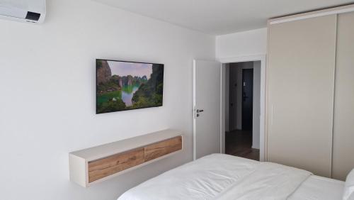 um quarto com uma cama e um quadro na parede em Valentini Apartments em Cluj-Napoca