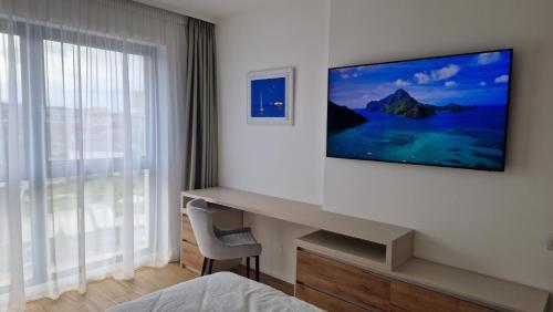 a hotel room with a television on the wall at Valentini Apartments in Cluj-Napoca