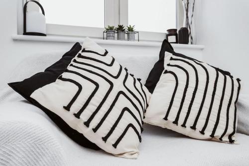 two black and white pillows on a bed at The Minimalist - Entire 1 bed flat near Gunwharf Quays, Ground Floor Flat Private Entrance in Portsmouth