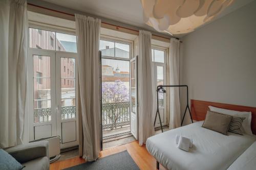 a bedroom with a bed and a large window at OPORTO GUEST Moinho de Vento Studios in Porto
