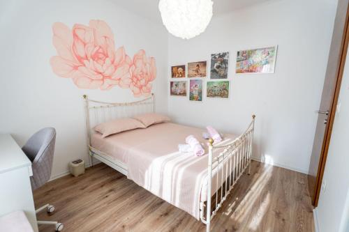 a bedroom with a crib with pink flowers on the wall at Holiday home Carpinus in Široki Brijeg