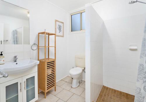 a white bathroom with a sink and a toilet at Cosy cottage by the sea in Gerroa