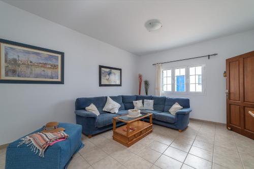 uma sala de estar com um sofá azul e uma mesa em Casa Vlaorda by HH em Caleta de Sebo