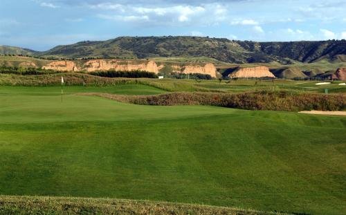a view of a golf course with mountains in the background at Sercotel El Encin Golf in Alcalá de Henares