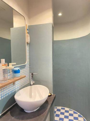La salle de bains est pourvue d'un grand lavabo blanc et d'un miroir. dans l'établissement Cosy Blue Nice, à Nice