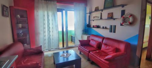 uma sala de estar com um sofá vermelho e uma mesa em A&K Sea view apartament 7 em Durrës