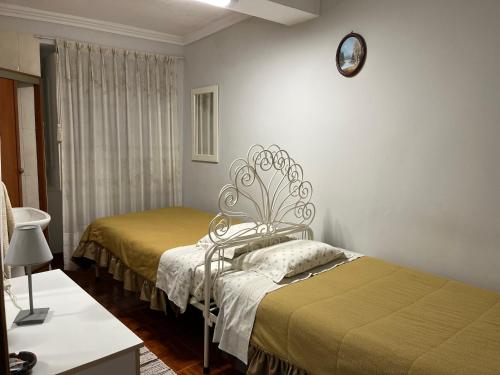 a room with two beds and a clock on the wall at Residencia do Norte in Lisbon
