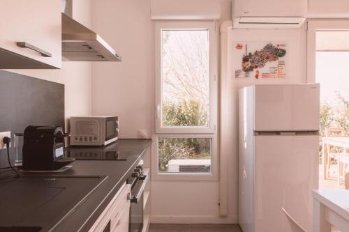 Il comprend une cuisine équipée d'un réfrigérateur et d'une fenêtre. dans l'établissement Studio with breathtaking view of Lake Monteux, à Monteux