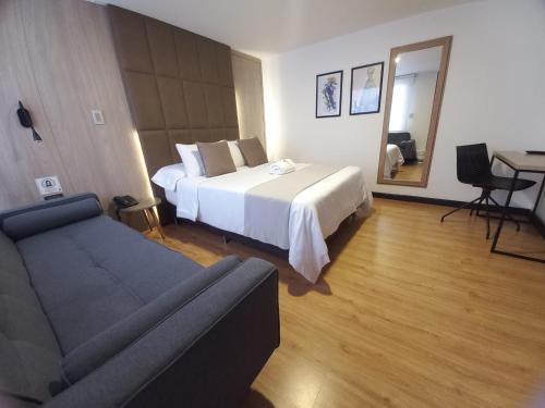 a hotel room with a bed and a couch at HOTEL SANTORI in Pasto
