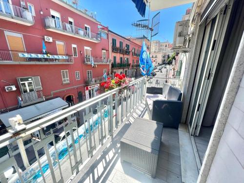a balcony of a building with a bench and buildings at A Casa dei Bruno B&B in Pozzuoli