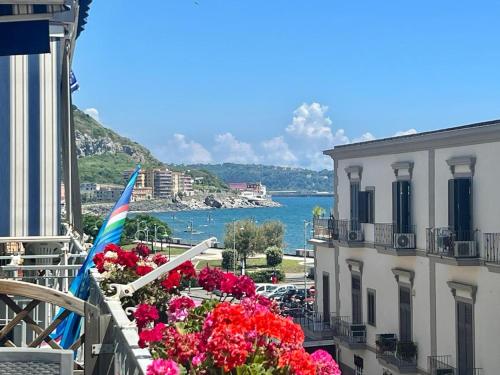 a balcony with flowers and a view of the water at A Casa dei Bruno B&B in Pozzuoli