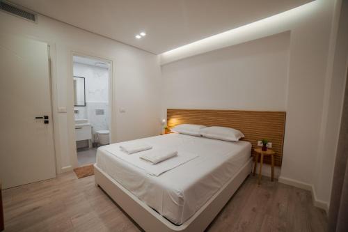 - une chambre blanche avec un grand lit et une salle de bains dans l'établissement SeA apartments, à Saranda