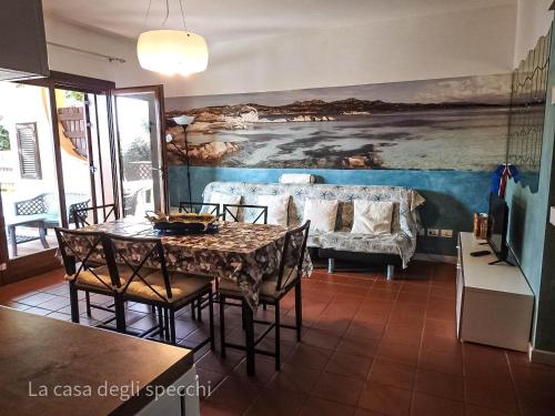 a dining room with a table and a couch at La Casa Degli Specchi-villetta con due giardini in La Maddalena
