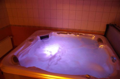 a large bath tub in a bathroom at Viesu Nams Vecupe in Birzgale