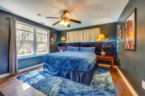 a blue bedroom with a bed and a ceiling fan at Jacksonville Vacation Rental with Deck! in Jacksonville