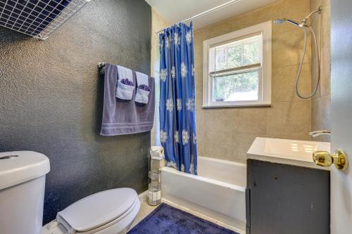 a bathroom with a toilet and a sink and a window at Jacksonville Vacation Rental with Deck! in Jacksonville