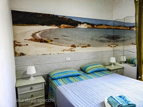 a bedroom with a large painting of a beach at La Casa Degli Specchi-villetta con due giardini in La Maddalena