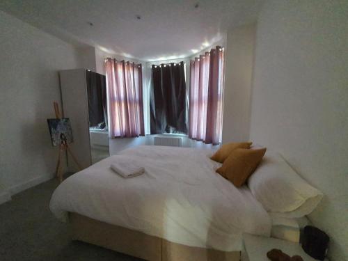 a bedroom with a large white bed in front of a window at Marble House in Edgware