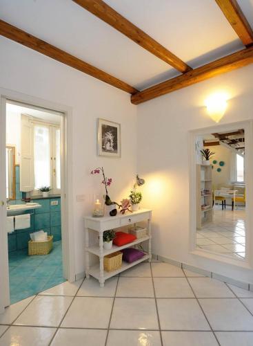a kitchen with white walls and a wooden ceiling at Loft Apartments by AMALFIVACATION in Amalfi