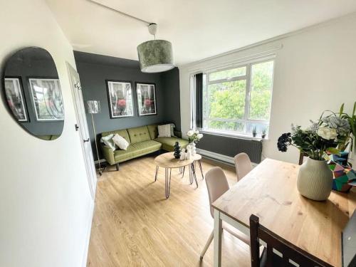 ロンドンにあるStylish 2 bedroom flat in Angel Central Locationのリビングルーム(緑のソファ、テーブル付)