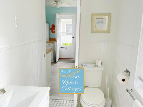 La salle de bains est pourvue de toilettes et d'un panneau. dans l'établissement Premier Waterfront Cottage 2, à Riverhead