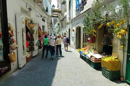 a group of people walking down a narrow street at Loft Apartments by AMALFIVACATION in Amalfi