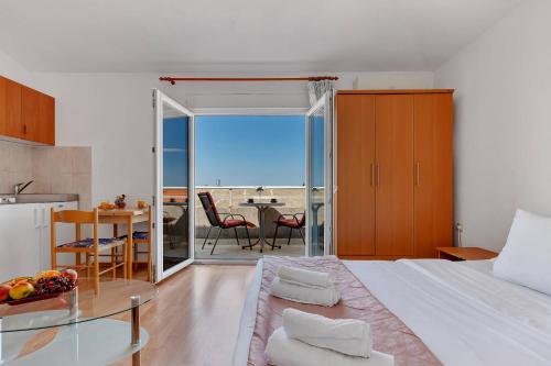a bedroom with a bed and a dining room with a table at Residence Apartments in Makarska