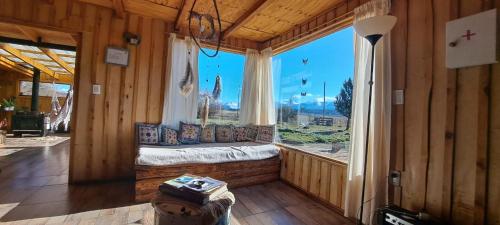 um quarto com uma grande janela com uma cama em Piuke Mapu Patagonia Hostel em Cholila