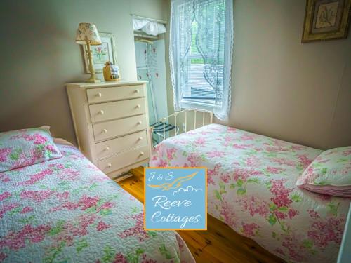 1 dormitorio pequeño con 2 camas y vestidor en Premier Waterfront Cottage 3, en Riverhead
