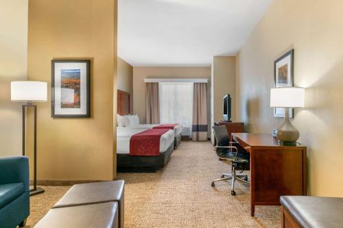 a hotel room with a bed and a desk at Comfort Suites in Forrest City