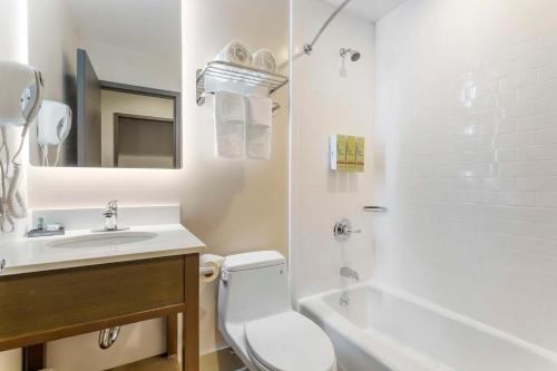 een witte badkamer met een toilet en een wastafel bij Best Western Brooklyn-Coney Island Inn in Brooklyn